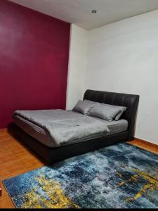 Bett in einem Zimmer mit lila Wänden in der Unterkunft Laguna Condo Resort Port Dickson in Port Dickson