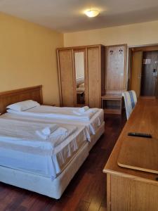 a hotel room with two beds and a table at Bellevue Residence RELAX ZONE in Bansko