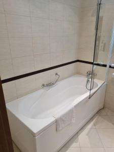a white bath tub in a bathroom with a shower at Bellevue Residence RELAX ZONE in Bansko +18 photos