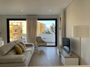 - un salon avec un canapé et une grande fenêtre dans l'établissement Apartamentos Bellevue Praia da Rocha, à Portimão