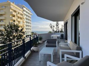 - un balcon avec des chaises et des tables dans un bâtiment dans l'établissement Apartamentos Bellevue Praia da Rocha, à Portimão