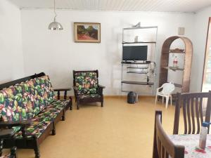 a living room with a couch and chairs and a tv at 0321.03 - Lagoinha - Casa- Condomínio Salga - 2 Dormitórios - 8 Pessoas - 2 Quadras Do Mar in Ubatuba