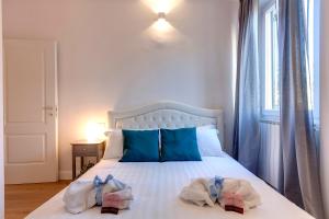 ein Schlafzimmer mit einem weißen Bett und Handtüchern darauf in der Unterkunft Mamo Florence - Abigail Apartment in Florenz