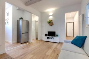 a living room with a couch and a refrigerator at Mamo Florence - Abigail Apartment in Florence