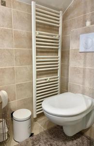 ein Badezimmer mit einer weißen Toilette in einem Zimmer in der Unterkunft Вілла Бовч in Jaremtsche