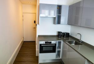 a kitchen with a sink and a stove at Nitehouse in Reading