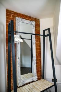 a mirror against a brick wall with a black frame at Nitehouse in Reading