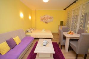 Zimmer mit 2 Betten, einem Sofa und einem Tisch in der Unterkunft Apartman Sladja in Vrnjačka Banja