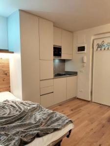 a bedroom with white cabinets and a bed in it at Appartamento Campiglio 2 in Madonna di Campiglio