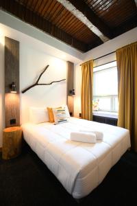 a large white bed in a room with a window at Hotel Le Bloc in Quebec City