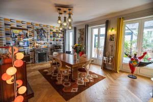 a dining room with a table and chairs and a fireplace at Le Jardin des Toiles in Triel-sur-Seine