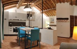 a kitchen with a table and blue chairs at Agriturismo I Cedri in Cortona