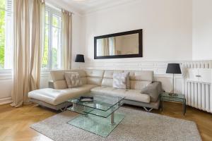 Appartement Luxueux Centre Ville في كولمار: غرفة معيشة مع أريكة وطاولة زجاجية