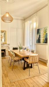 a dining room with a wooden table and chairs at l'Appartement Grand Théatre in Bordeaux +17 photos