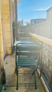a group of green benches sitting on a balcony at l'Appartement Grand Théatre in Bordeaux