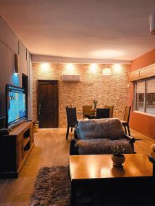 ein Wohnzimmer mit einem Sofa und einem TV in der Unterkunft El Refugio - Hotel Mariscala in Mariscala