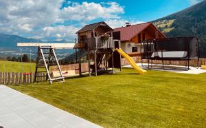 un patio con parque infantil con tobogán en AUSZEIT Appartement, en Schladming