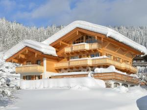 ein schneebedecktes Blockhaus in der Unterkunft Ferienhaus Landenhammer in Reit im Winkl