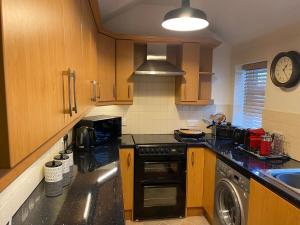 uma cozinha com armários de madeira e um forno com placa de fogão em Number 19 - Victorian Town House em Clitheroe