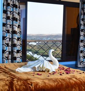 a swan decoration on a bed in front of a window at ASWAN NILE PALACE (swimming pool-rooftop-Nile view) in Aswan