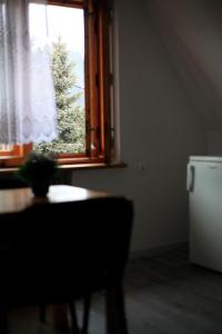 a room with a table and a window with a christmas tree at Pokoje Gościnne u Lańdy in Poronin