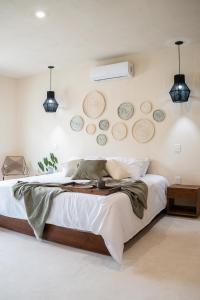 um quarto com uma cama com pratos na parede em Mayanah Bacalar em Bacalar