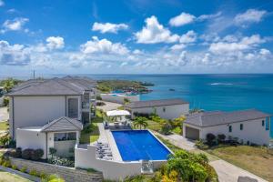 an aerial view of a house with a swimming pool and the ocean at Grenada Condo in Lower Woburn