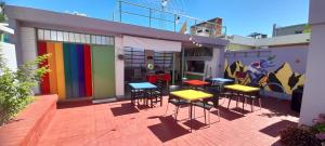 grupa stołów i stołków na patio w obiekcie Bed & Bike Hostel w mieście San Lorenzo