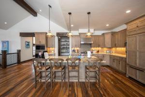 Una cocina con gabinetes de madera y una mesa con sillas. en Spacious Elegance, 5 en-suites, hiking trail to town, packed with amenities!, en Breckenridge