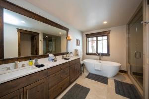 Un baño con bañera y un espejo grande. en Spacious Elegance, 5 en-suites, hiking trail to town, packed with amenities!, en Breckenridge 21 fotos más
