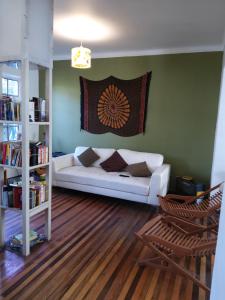 ein Wohnzimmer mit einer weißen Couch und einem Bücherregal in der Unterkunft Ventana Sur Hostal in Santiago