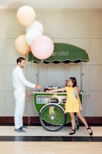 Un uomo e una ragazza in piedi accanto a un carretto degli hot dog di ette luxury hotel & spa a Orlando