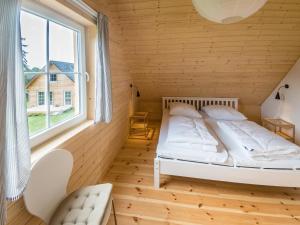 Schlafzimmer mit einem Bett und einem Fenster in der Unterkunft Schmidt's Ferienhäuser bei Zingst in Lüdershagen