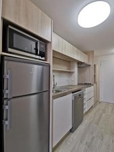 a kitchen with a stainless steel refrigerator and a microwave at Les jardins de la Côte d'azur in Saint-Mandrier-sur-Mer