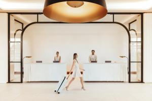 a woman walks past a reception desk in a lobby at ette luxury hotel & spa - Near Disney Theme Parks in Orlando