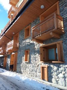 a building with wooden balconies and a cat standing outside at Ampio e grazioso trilocale con vista panoramica in Chiesa in Valmalenco