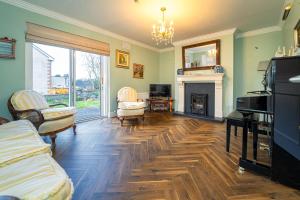 a living room with a piano and a fireplace at Five Ferns House in Westport
