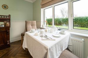 a table with cups and saucers on it next to a window at Five Ferns House in Westport