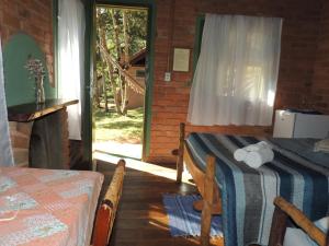 een slaapkamer met een bed, een tafel en een open haard bij Reserva Canto da Vida Chalés e Camping in Lima Duarte