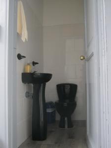 a bathroom with a black toilet and a sink at ANGIE`s HOUSE in Manizales