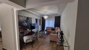 sala de estar con mesa, sillas y sofá en Deka luxury apartment, en Tríkala