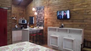 a kitchen with a counter and a bar in a room at Pousada Sitio Bella Vista- Vermelha in Urupema