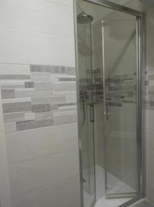 y baño con ducha y puerta de cristal. en Morena Studio Apartment, en Asolo
