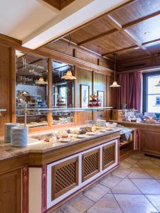 a large kitchen with a large counter with food at Alte Post in Ellmau