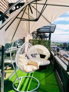 a hammock and an umbrella on a balcony at Glasgow City Centre G1 PENTHOUSE with RiverViews - Duplex (4 Bedrooms, 3 Bathrooms, Kitchen, 1 Living room, 1 Dining room, 2 Terraces, Triple Garage 3 Parking spaces 'e-charging', Top Floor, 2050 sq ft, Merchant City) in Glasgow