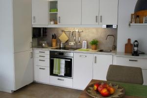 a kitchen with white cabinets and a bowl of fruit on a table at Ferienwohnung Salzburg in Bad Reichenhall