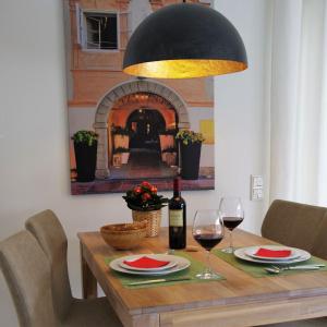 a table with a bottle of wine and two glasses at Ferienwohnung Salzburg in Bad Reichenhall