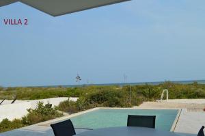 una piscina con mesa y sillas junto a la playa en Villas Las Tunas 2 - Yucatan Home Rentals, en Uaymitun