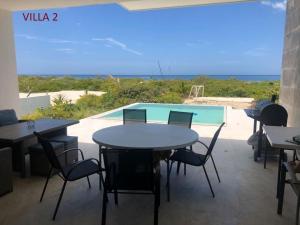 un patio con mesas y sillas y una piscina en Villas Las Tunas 2 - Yucatan Home Rentals, en Uaymitun