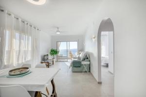 Apartament Roses Vista Mar في روساس: غرفة بيضاء مع طاولة وغرفة معيشة